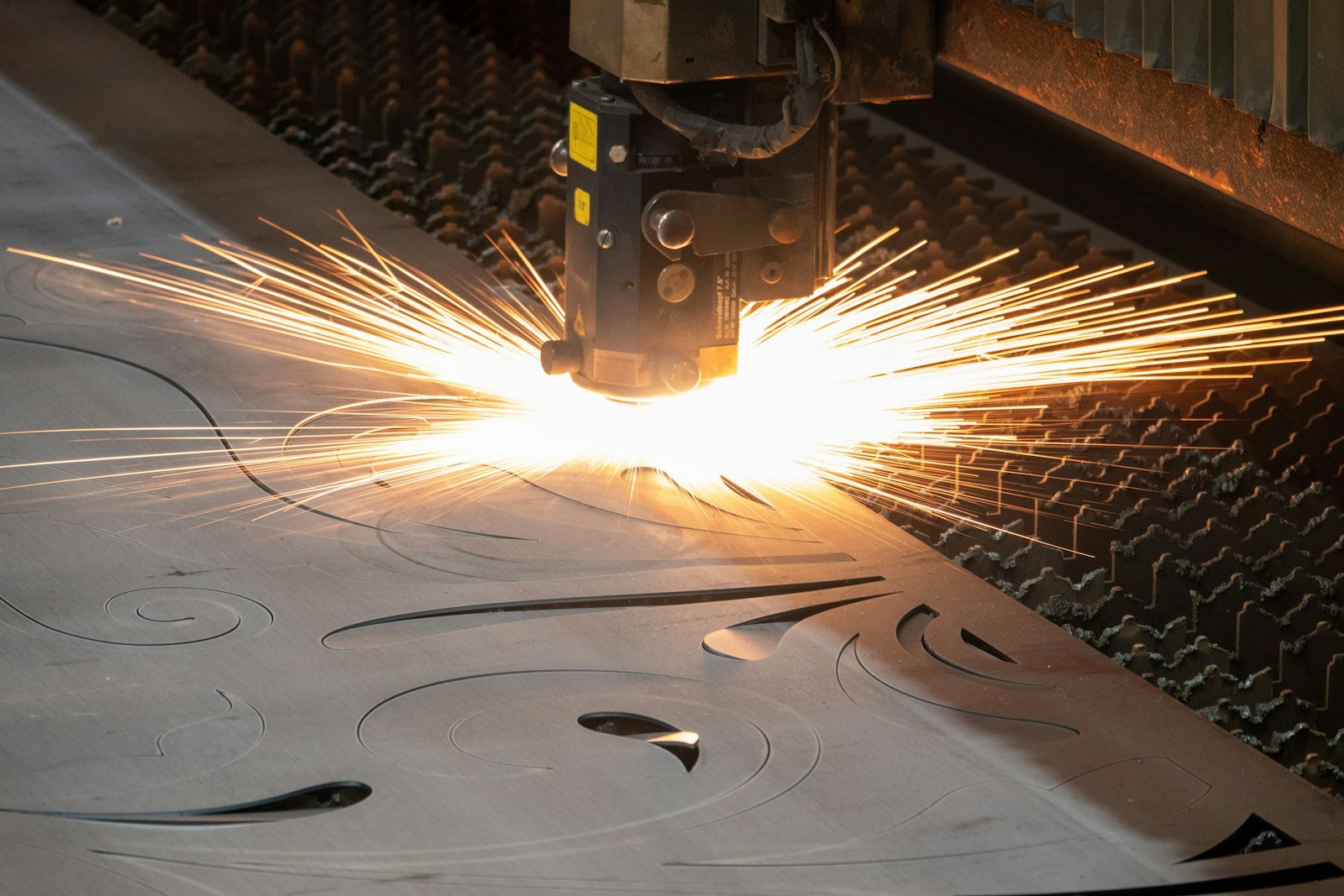 Découpe laser d'une pièce métallique, gerbe d'étincelles sur la machine