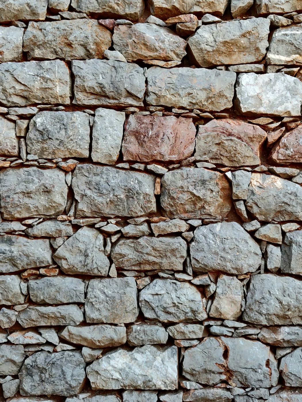 Texture d'un mur en pierres assemblées, savoir-faire de maçonnerie